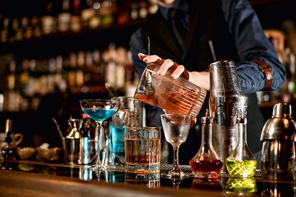 Person pouring a drink into a glass at an event